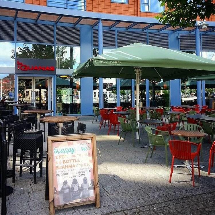 Outdoor dining area at Las Iguanas Portsmouth with colorful chairs for casual networking events.