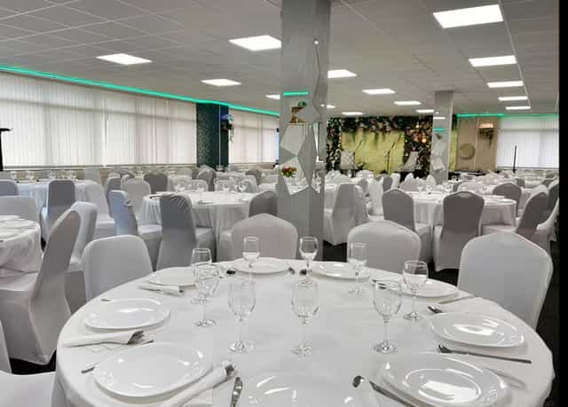 Elegant ACAA Hall banquet setup with floral backdrop for weddings and corporate events.