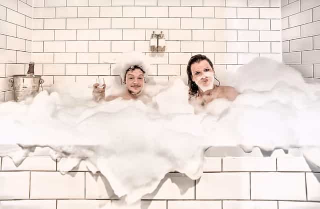 "Playful moment in luxurious bubble bath at Hotel Pelirocco for corporate retreats."