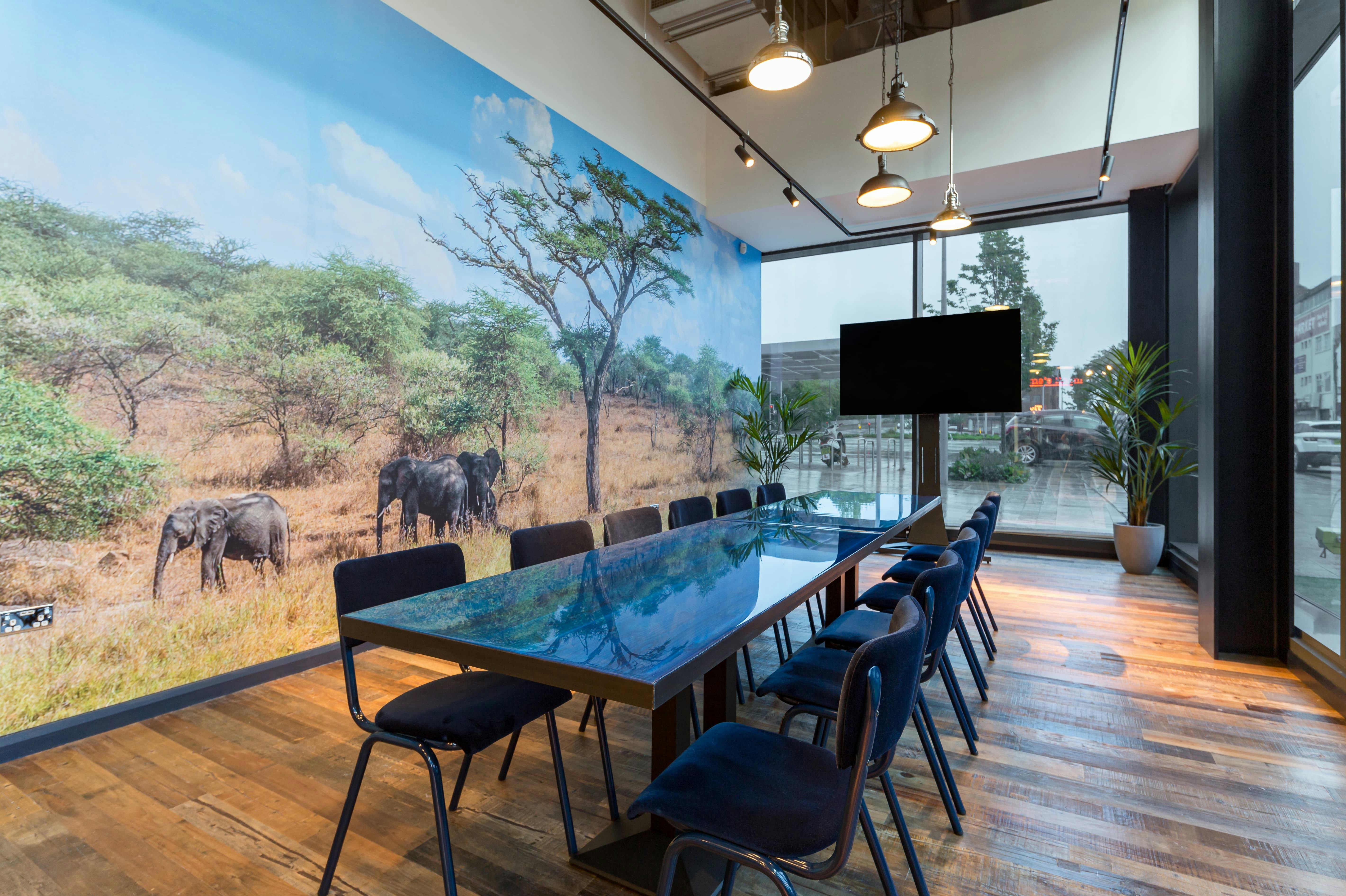 Modern meeting room with elephant mural, ideal for creative brainstorming sessions.