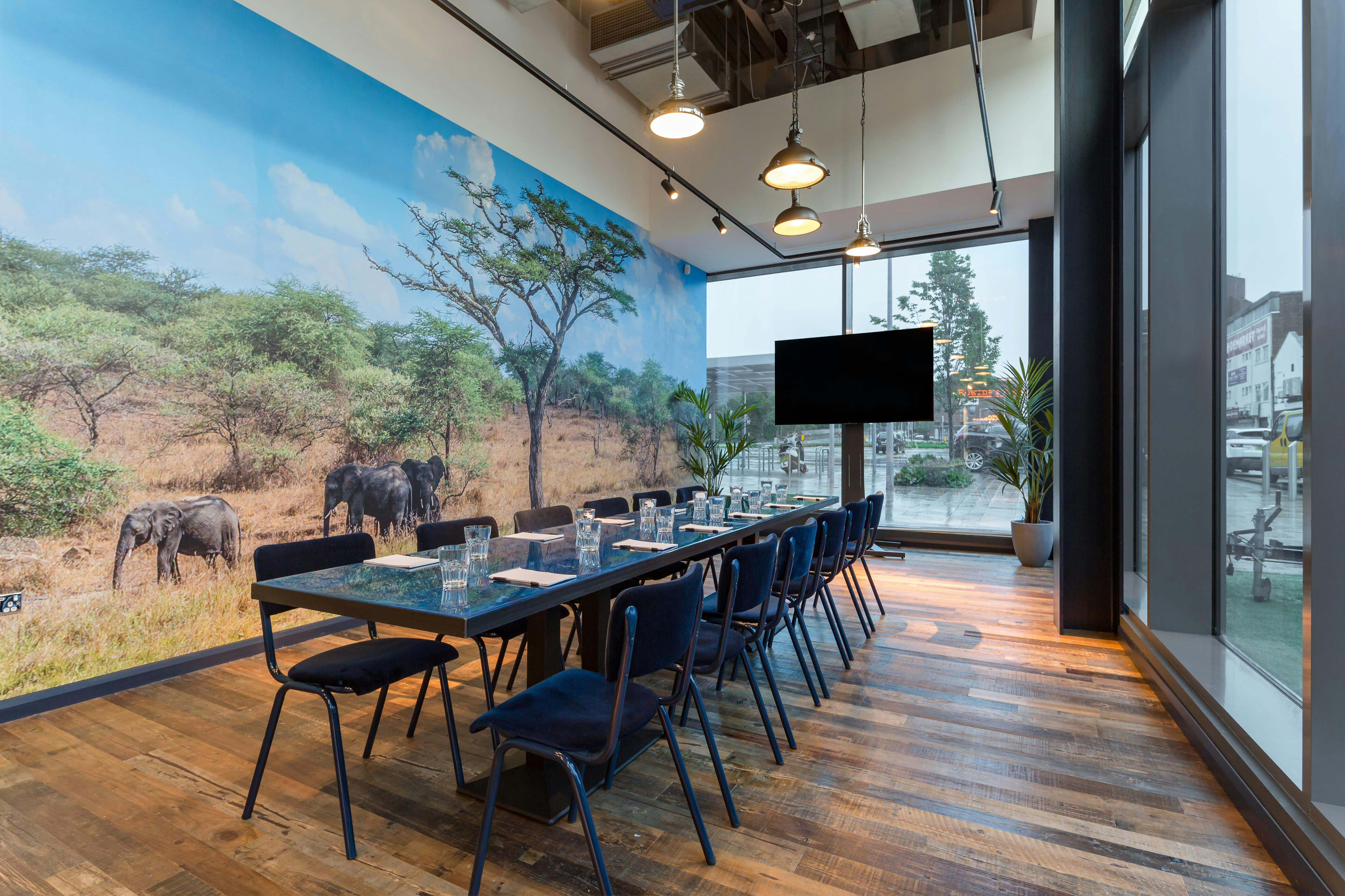 Modern meeting room with elephant mural, perfect for brainstorming and team-building events.