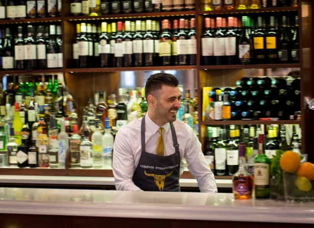Bartender in stylish bar at London Steakhouse, perfect for events and gatherings.