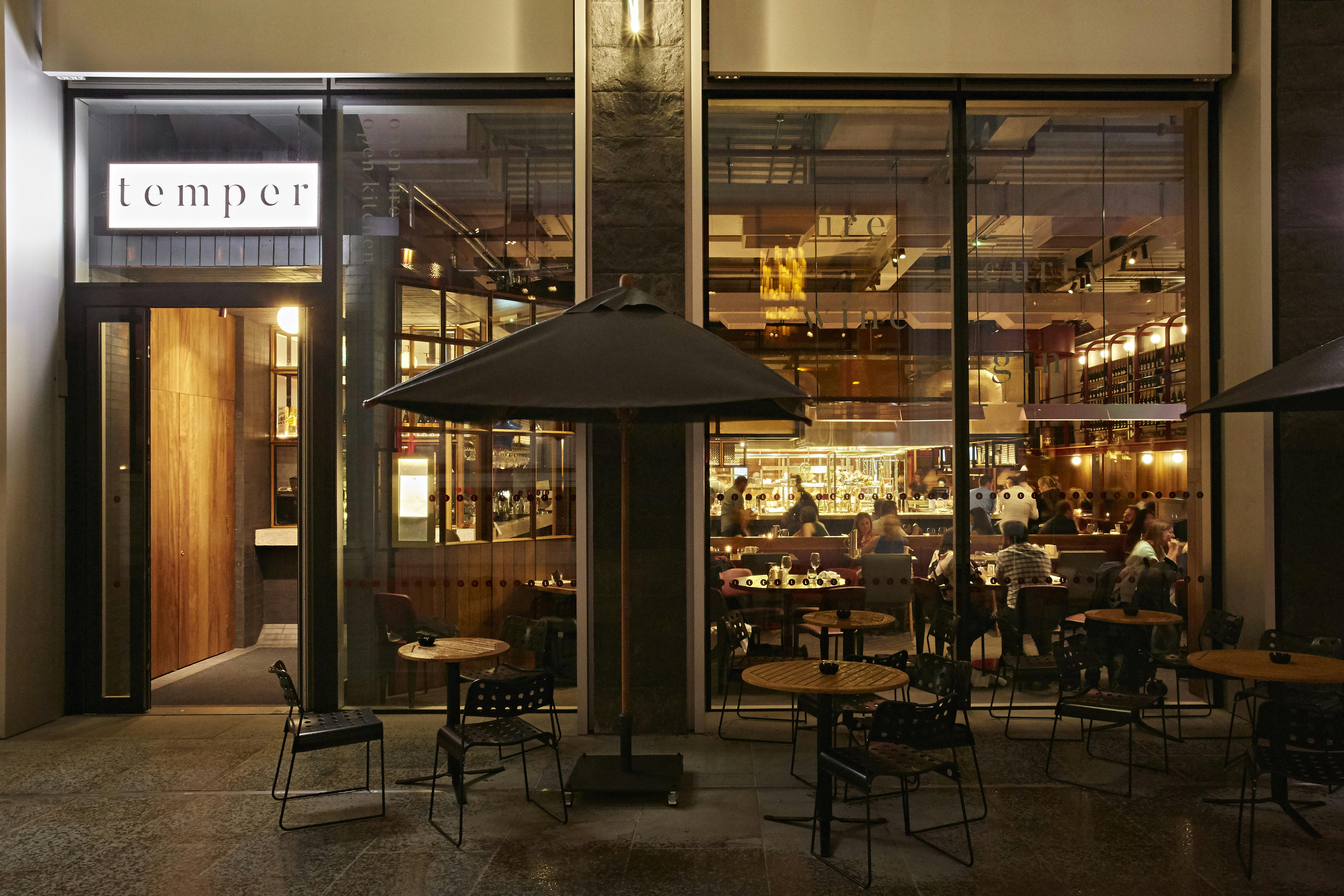 Modern restaurant entrance with outdoor seating, perfect for intimate gatherings and events.