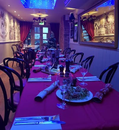 Cozy dining table with red tablecloth at Café Rouge for holiday gatherings or corporate events.