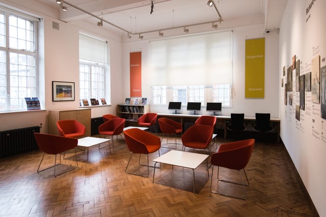 Modern meeting space with red chairs at Glynn Vivian Art Gallery for workshops and networking.