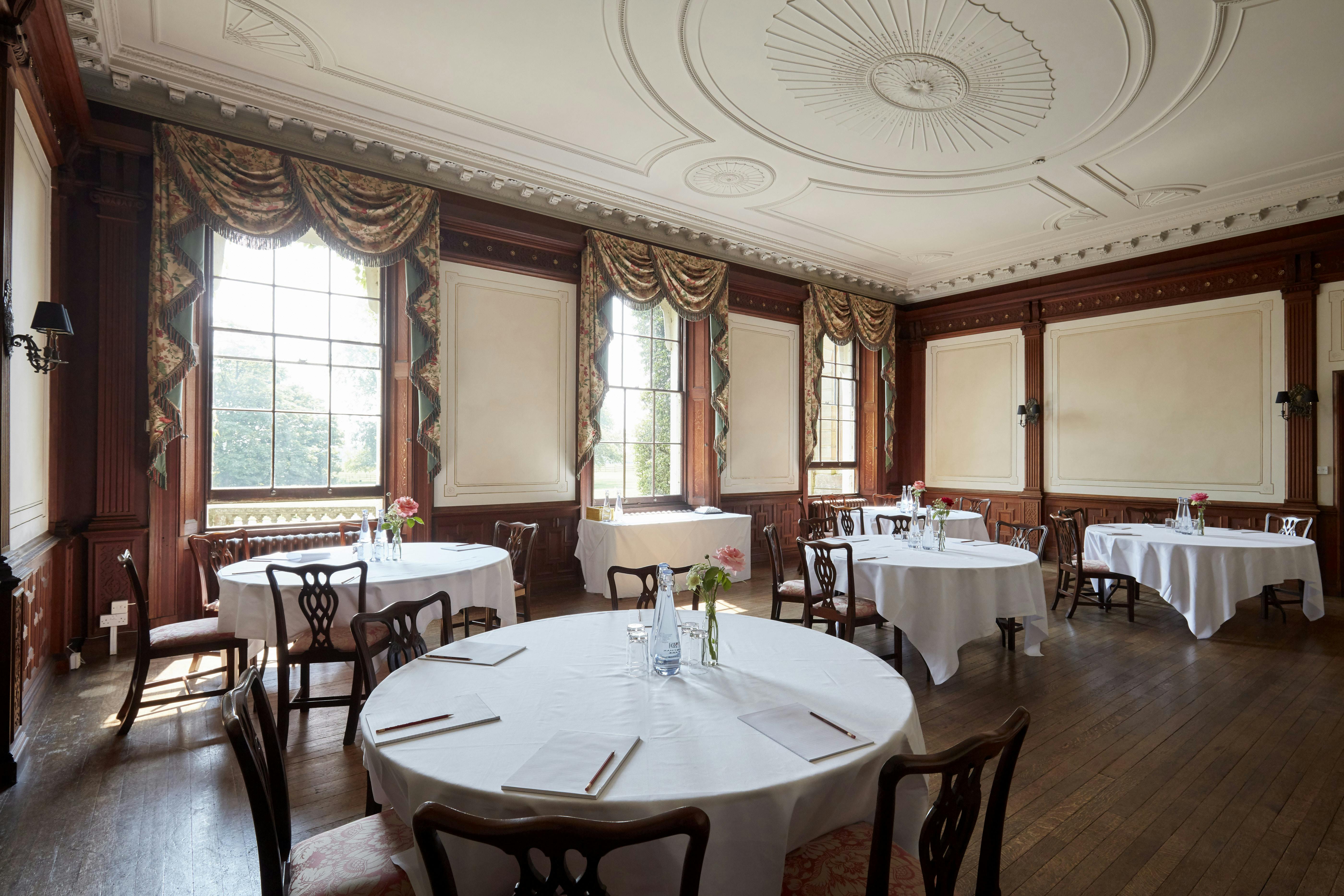 Elegant stateroom with round tables, perfect for corporate events and weddings.