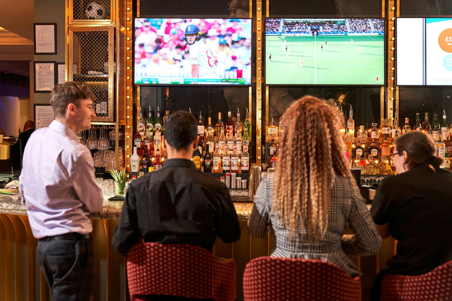 Vibrant SOUND Sports Bar with dual screens, ideal for networking events and casual gatherings.