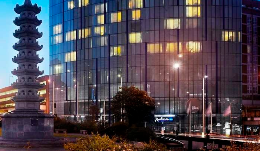 Light Suite at Radisson Blu Birmingham, modern hotel with illuminated windows for evening events. - Banner