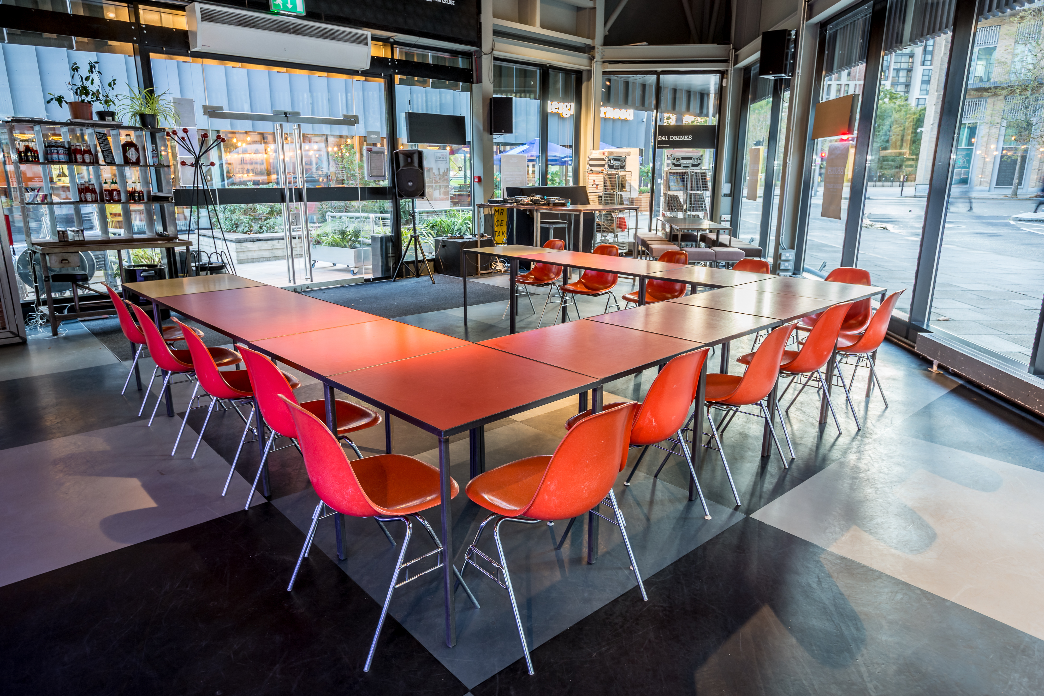 Modern meeting space with U-shaped table and vibrant orange chairs for workshops.