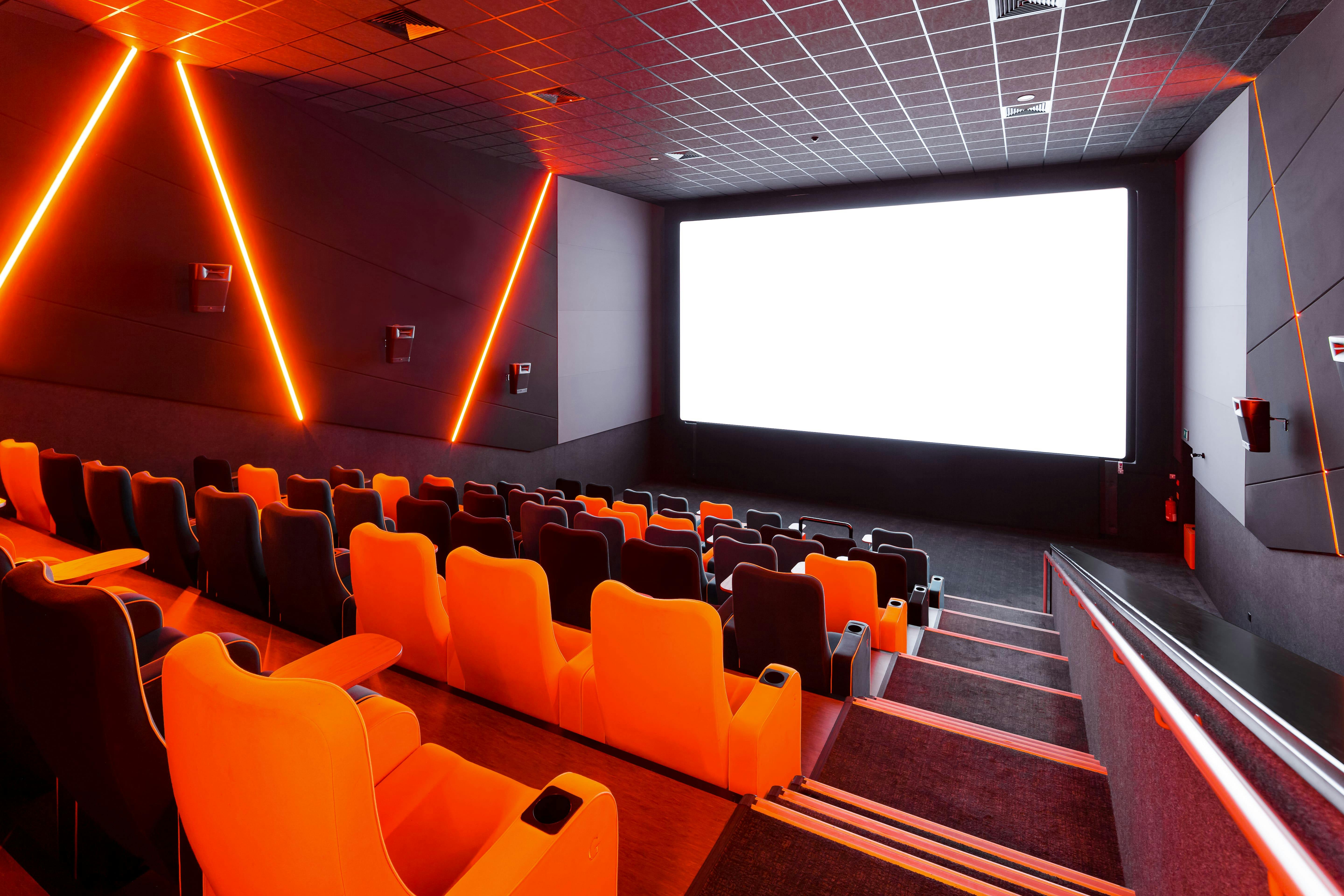 Modern cinema with vibrant orange seating, ideal for film screenings and corporate events.