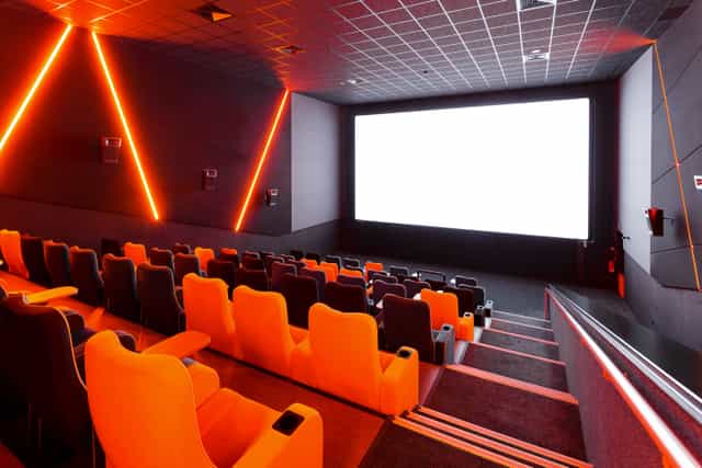 Modern cinema with vibrant orange seating, ideal for film screenings and corporate events.