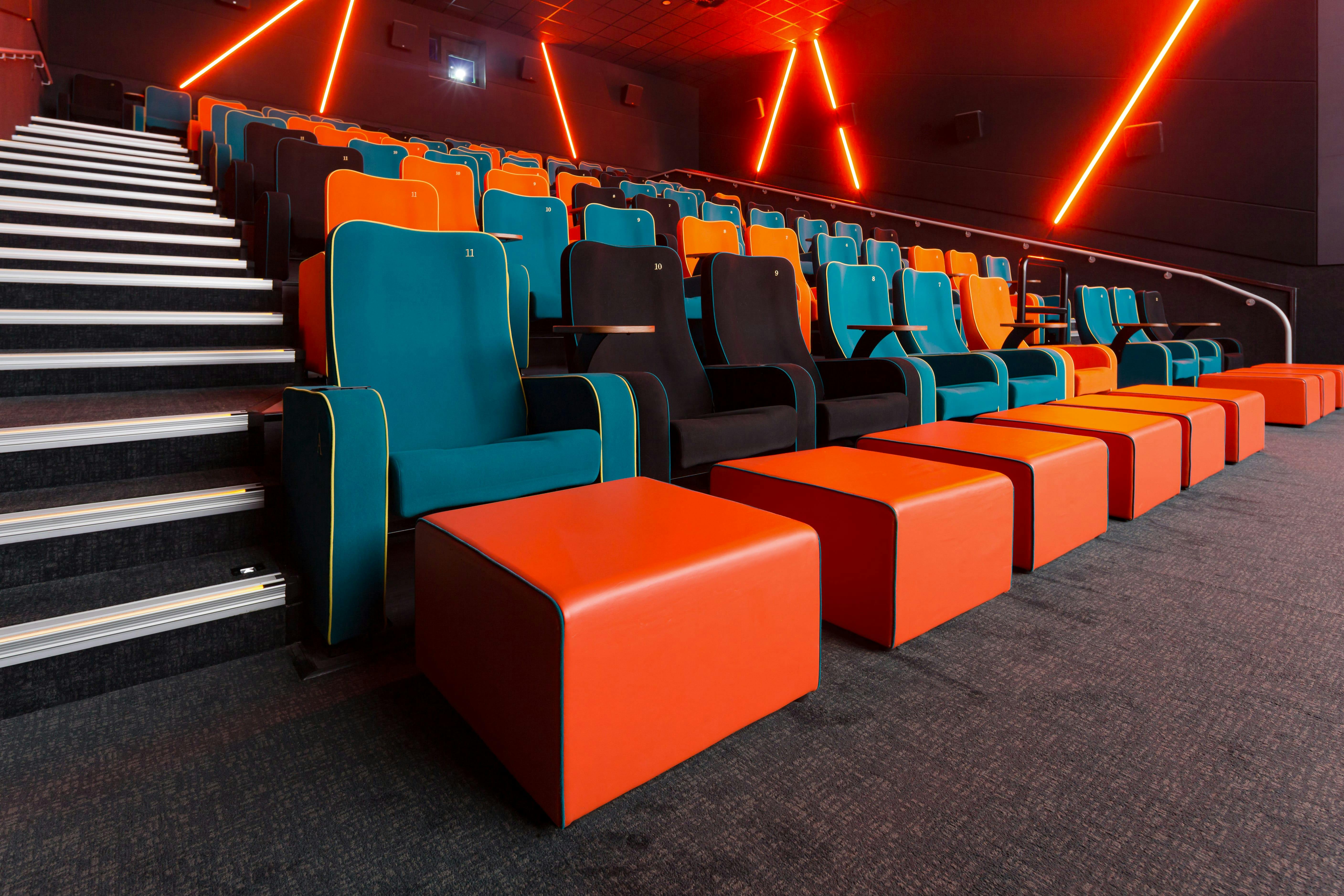 Modern auditorium with teal and orange seating for engaging film screenings and presentations.