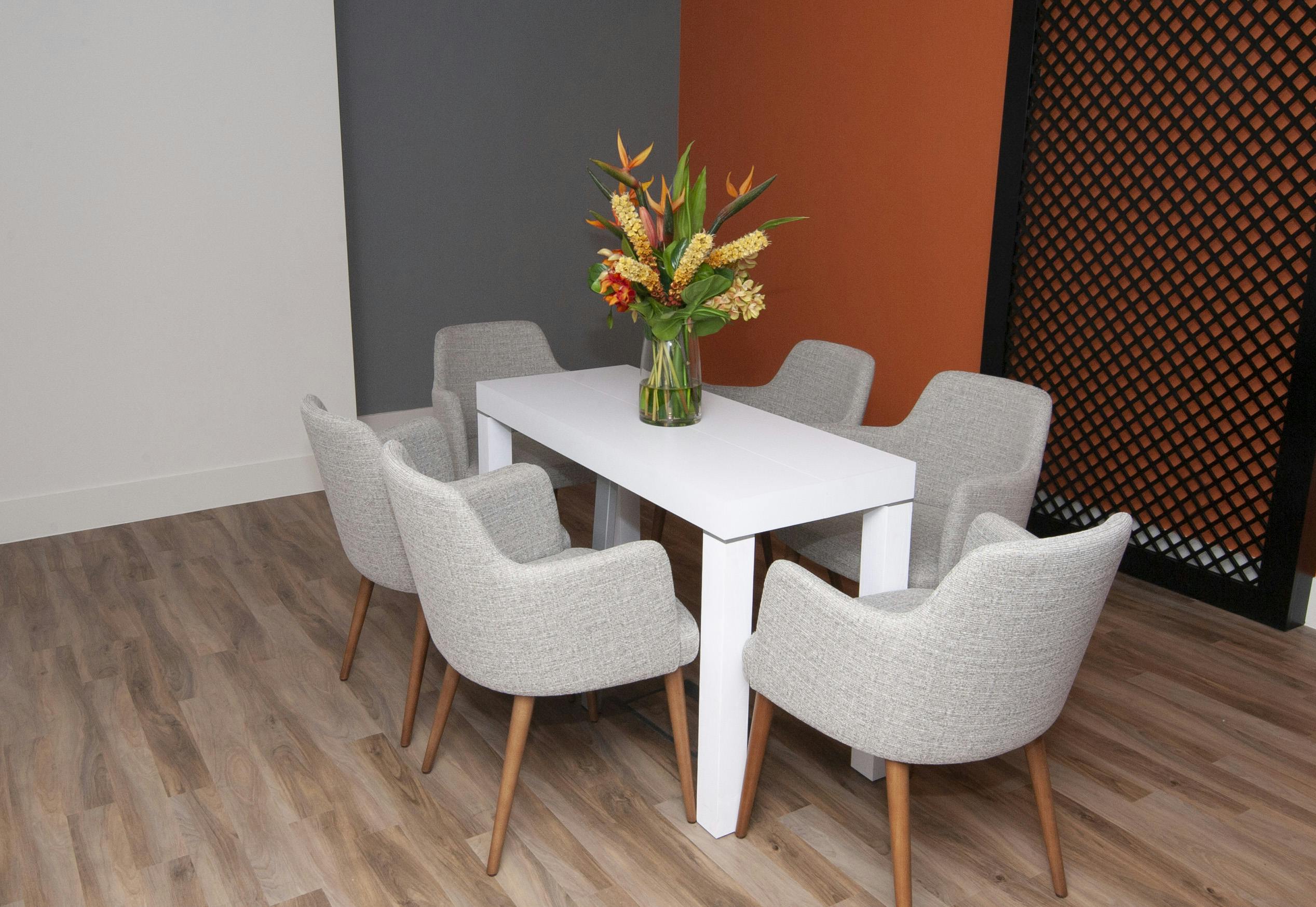 Modern pop-up meeting room at Holiday Inn Kensington, featuring a white table and floral decor.