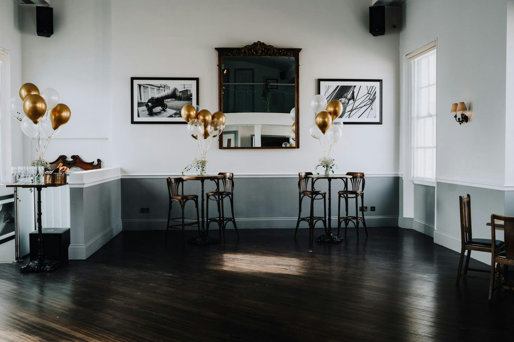 Elegant event space at The Admiral Hardy with gold balloons and natural light.