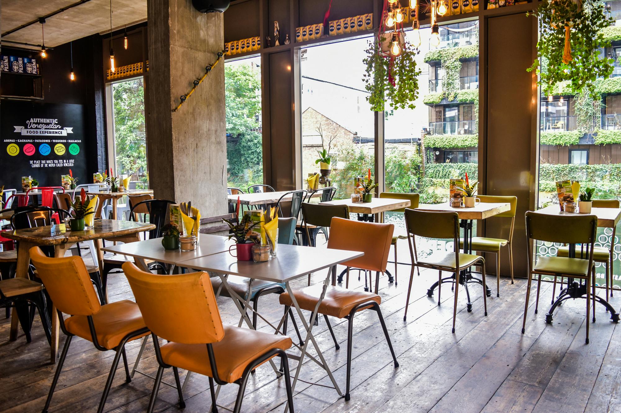 Vibrant event space with colorful chairs at Arepa & Co, ideal for casual meetings and networking.