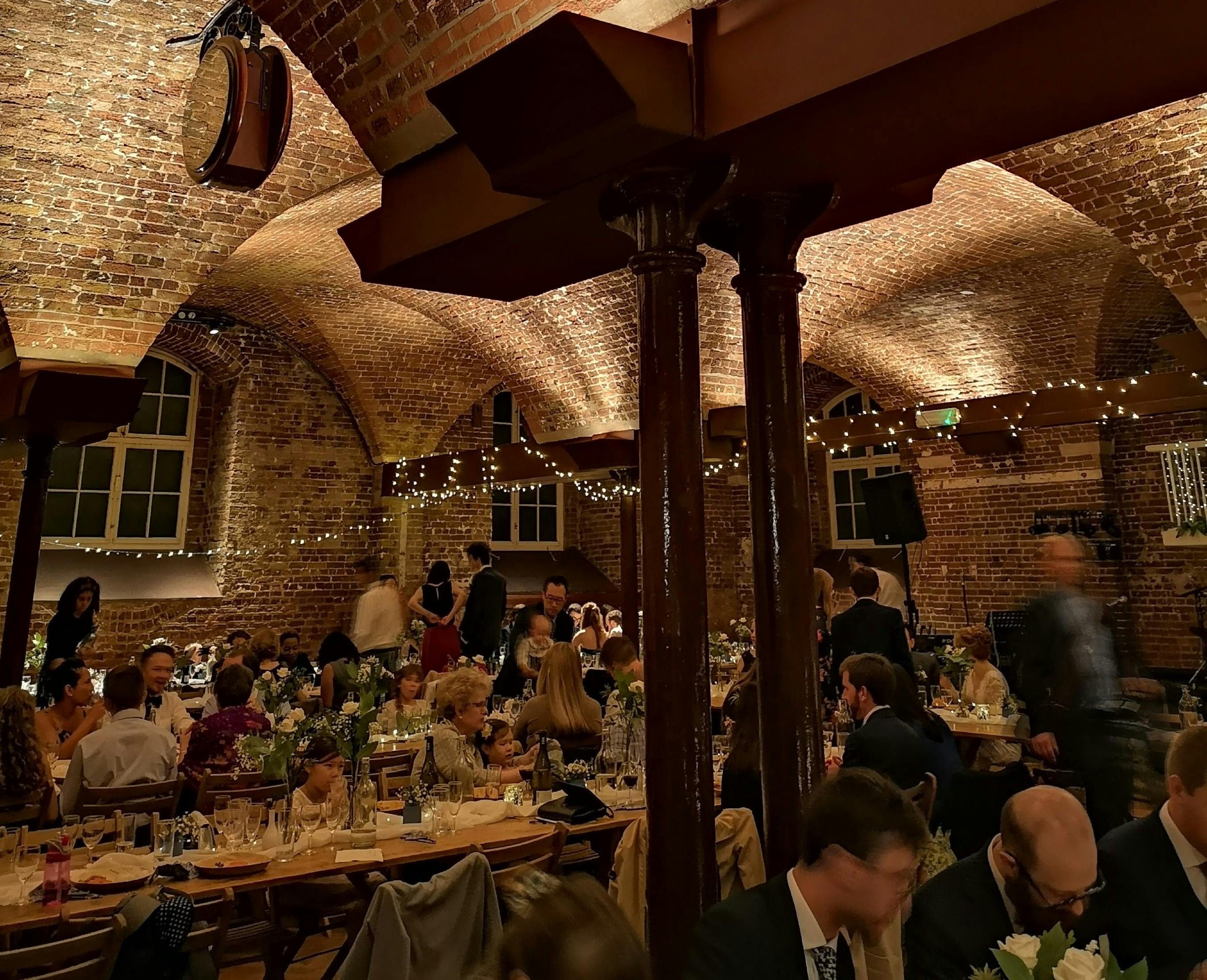 Elegant event space in The Crypt with string lights, perfect for networking and celebrations.