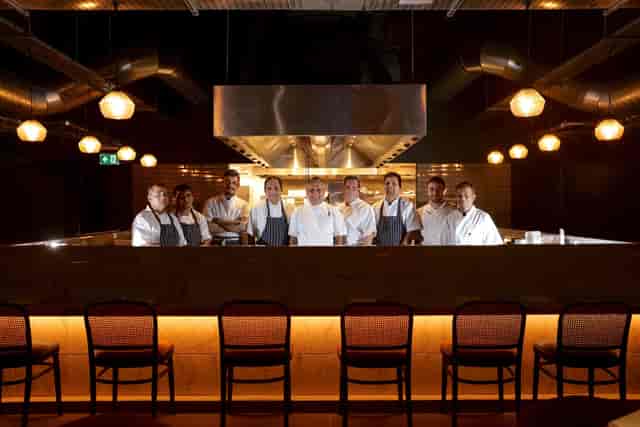 Professional kitchen team in sleek Cinnamon Kitchen Battersea, perfect for exclusive dining events.