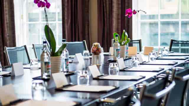 Elegant meeting room with orchids at Apex Waterloo Place Hotel for professional gatherings.