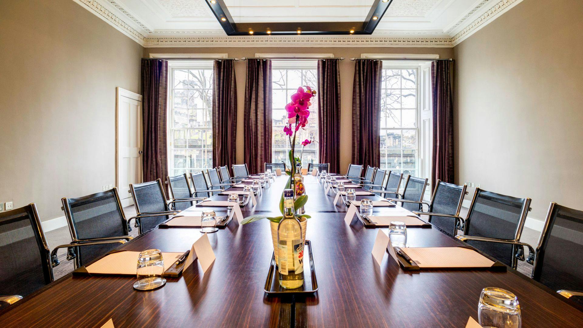 Elegant meeting room with orchid centerpiece, perfect for corporate events and retreats.