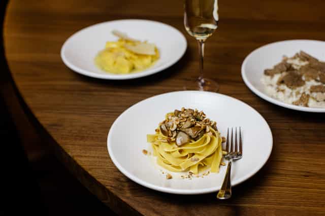 Elegant dining setup with gourmet pasta for exclusive corporate events in Sette.