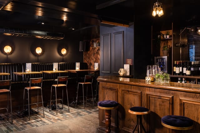 Intimate bar venue with warm lighting, perfect for networking events and gatherings.