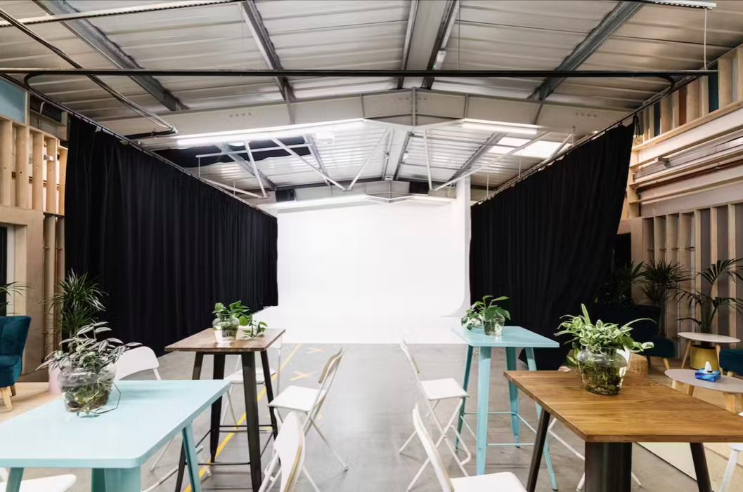 Versatile event space with white backdrop, ideal for presentations and workshops. - Banner