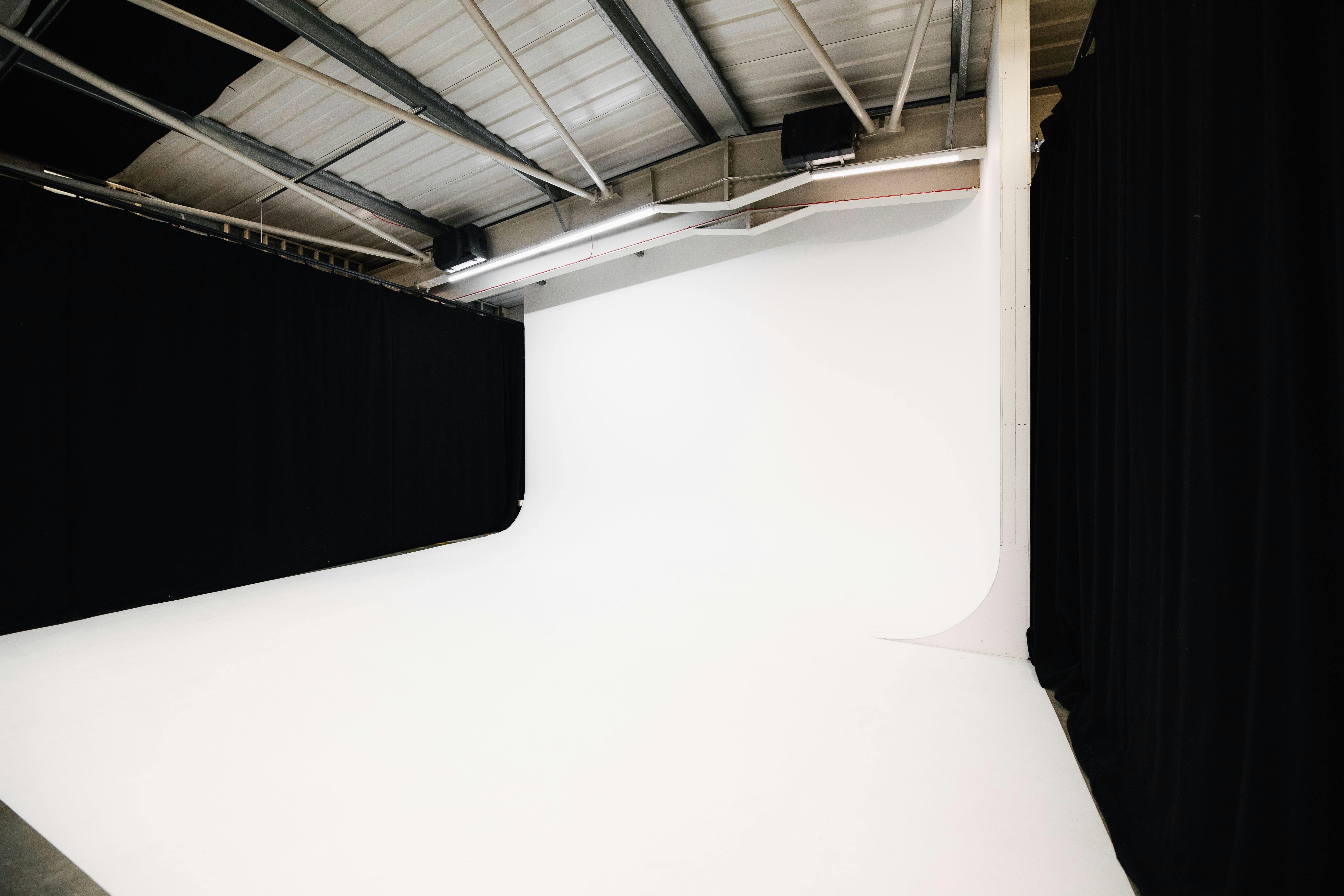 Versatile event space with seamless white backdrop for presentations and creative shoots.