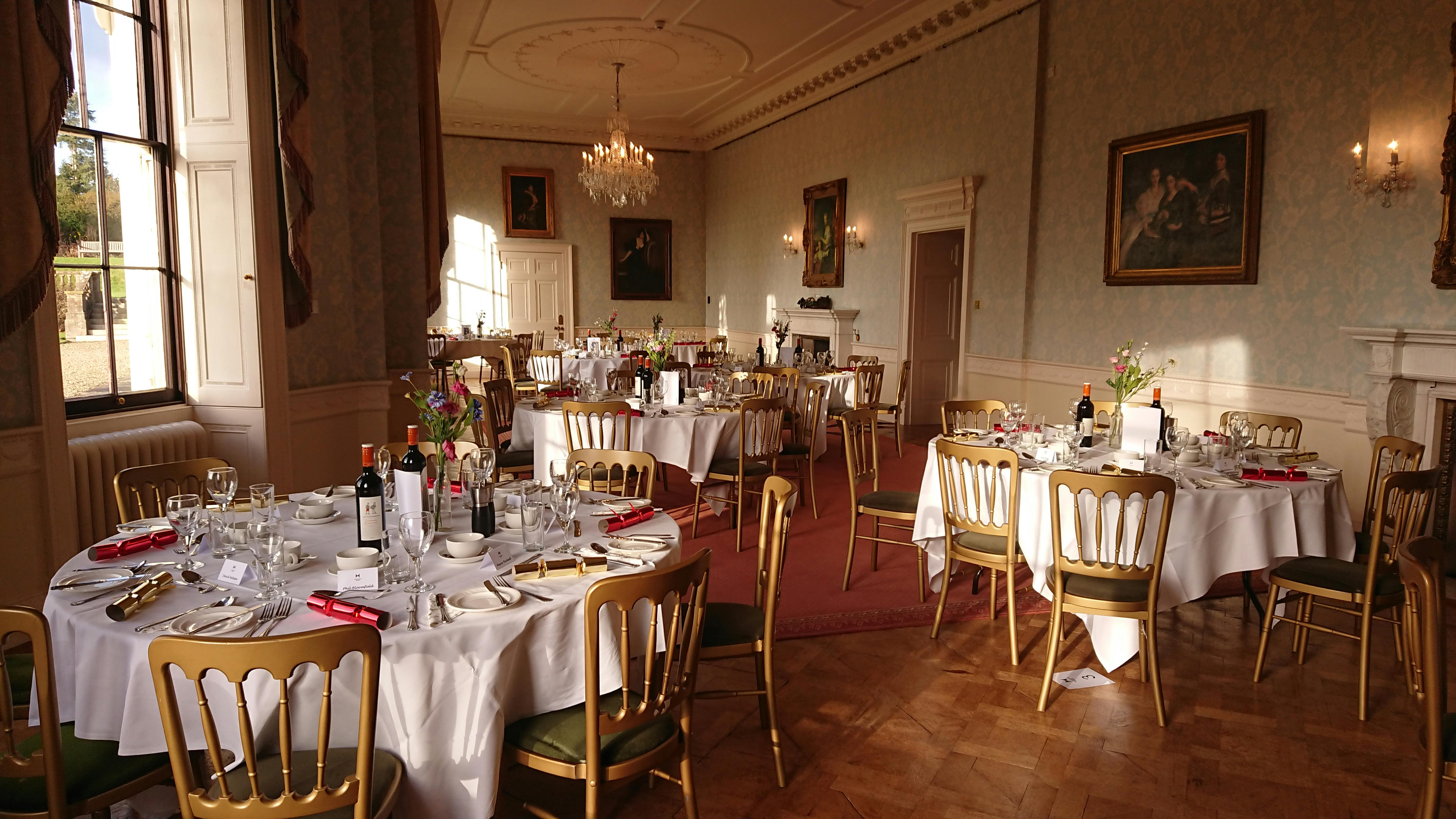 Elegant ballroom dining setup with white linens for formal events and galas.