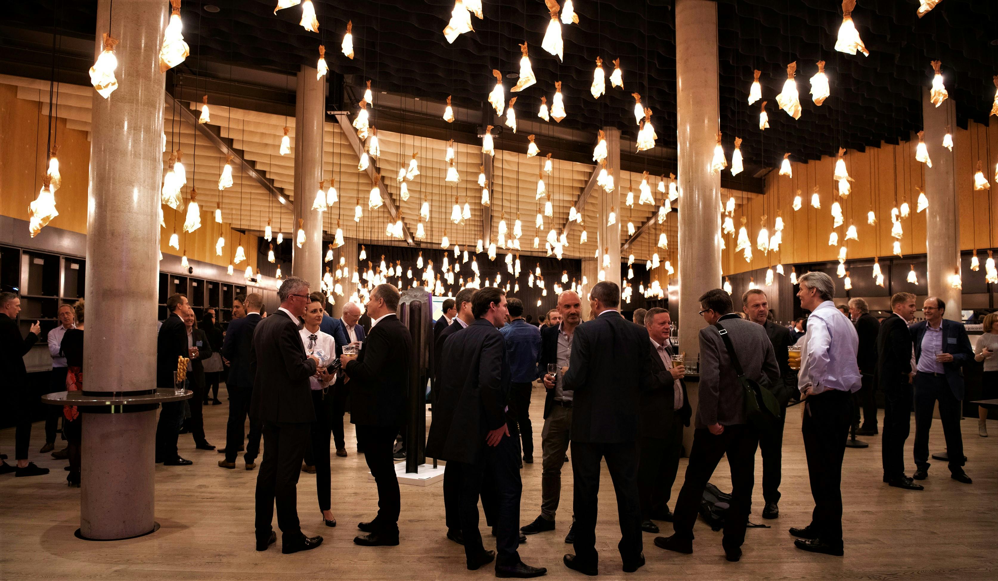 Vibrant networking event in Bridge Theatre's stylish Main Foyer with warm lighting.