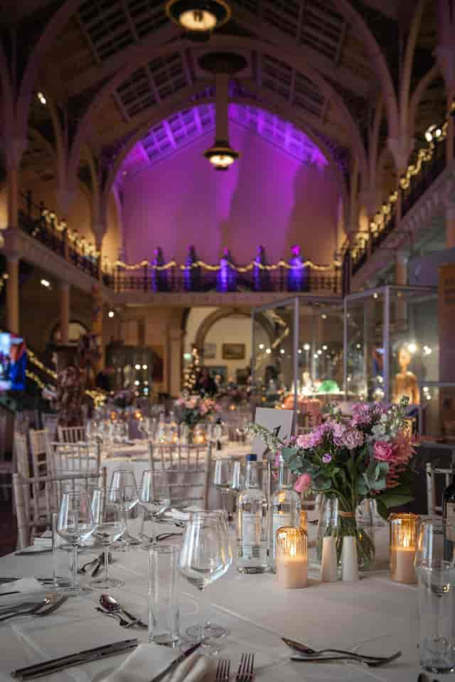 Elegant event space at Birmingham Museum, featuring floral centerpieces and high ceilings.