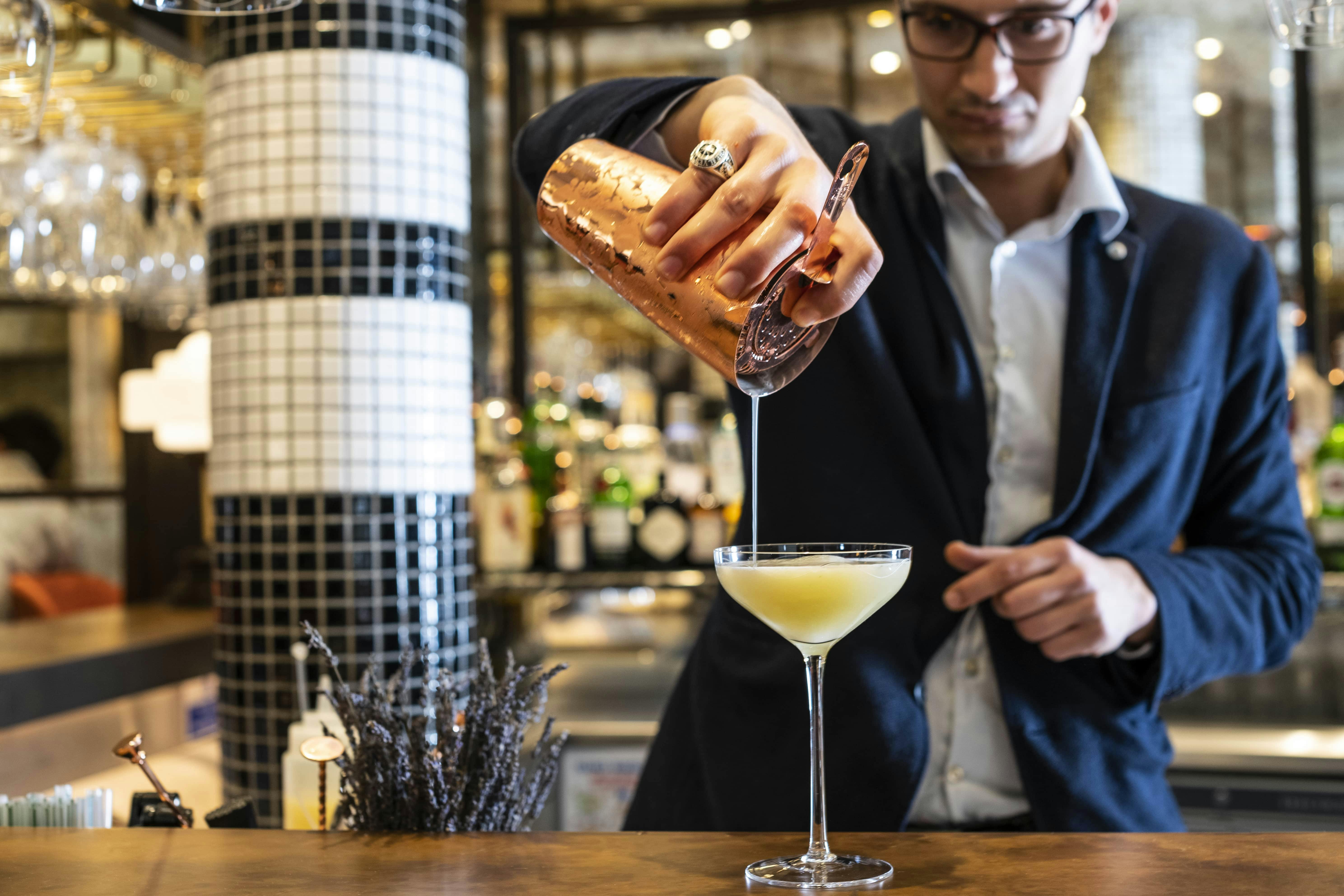 Bartender pouring cocktail at Sloane Place Bar, perfect for events and networking.