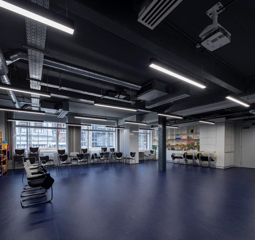 Versatile training room with natural light, ideal for workshops and team gatherings.