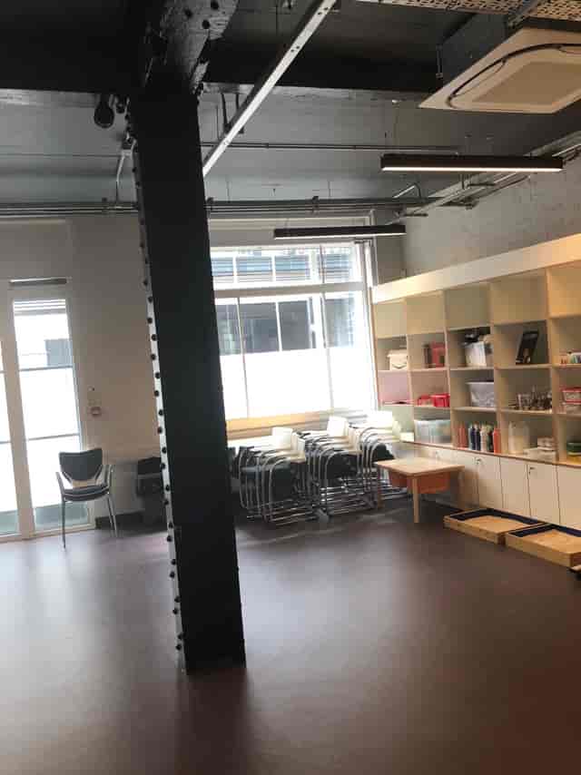 Versatile training room with natural light, ideal for workshops and gatherings.