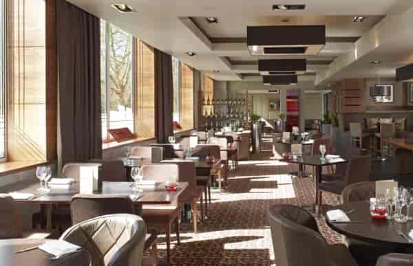 Modern restaurant with large windows, ideal for intimate meetings and events.