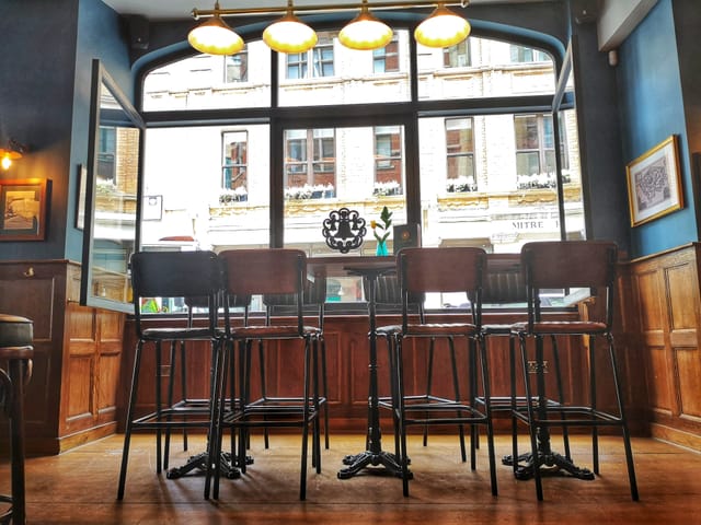 Cozy Main Bar at The Trinity Bell with high-backed stools, perfect for networking events.