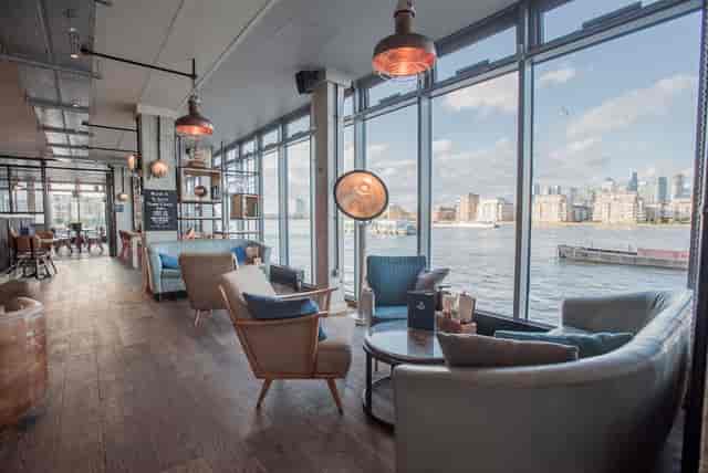 Stylish waterfront venue with large windows, ideal for networking events and meetings.