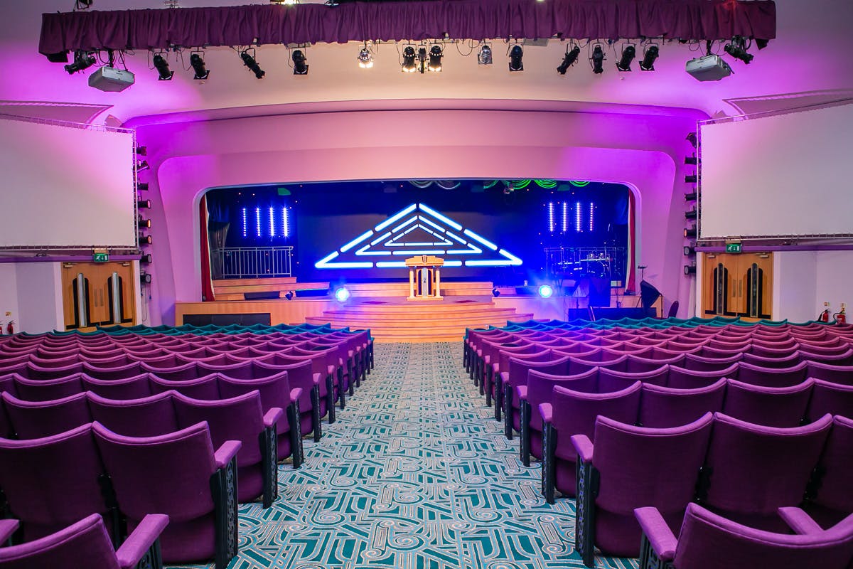 Modern event space with dynamic lighting and tiered seating for conferences and performances.