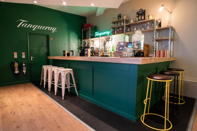 Stylish bar area with green wall, ideal for networking events and cocktail receptions.