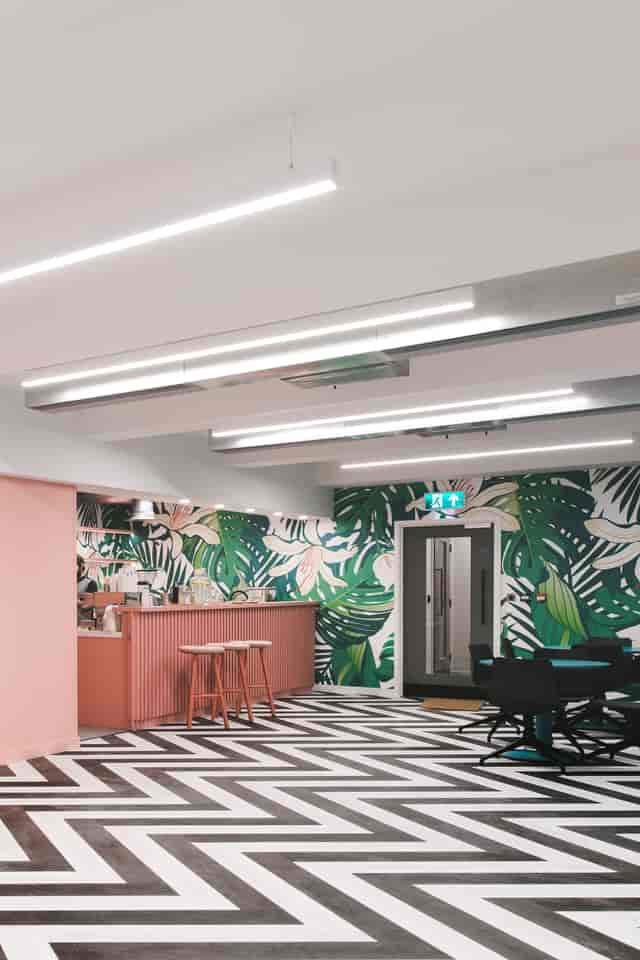 Vibrant meeting space with tropical mural for team-building and networking events.