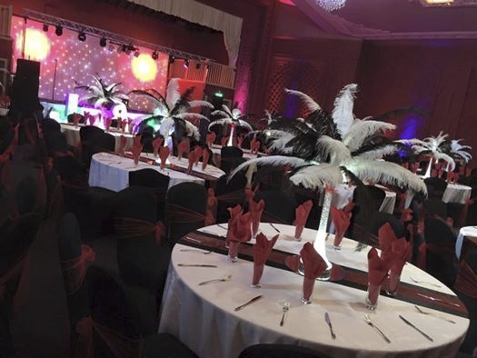 Elegant event space at Burton Ritz with feather centerpieces for gala gatherings. - Banner