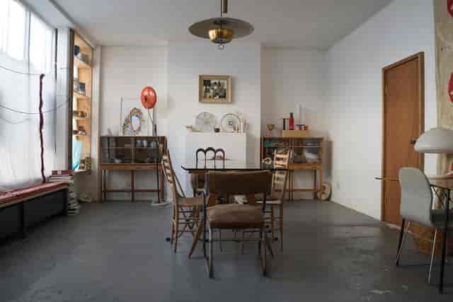 Versatile minimalist meeting space with natural light for creative events and gatherings.