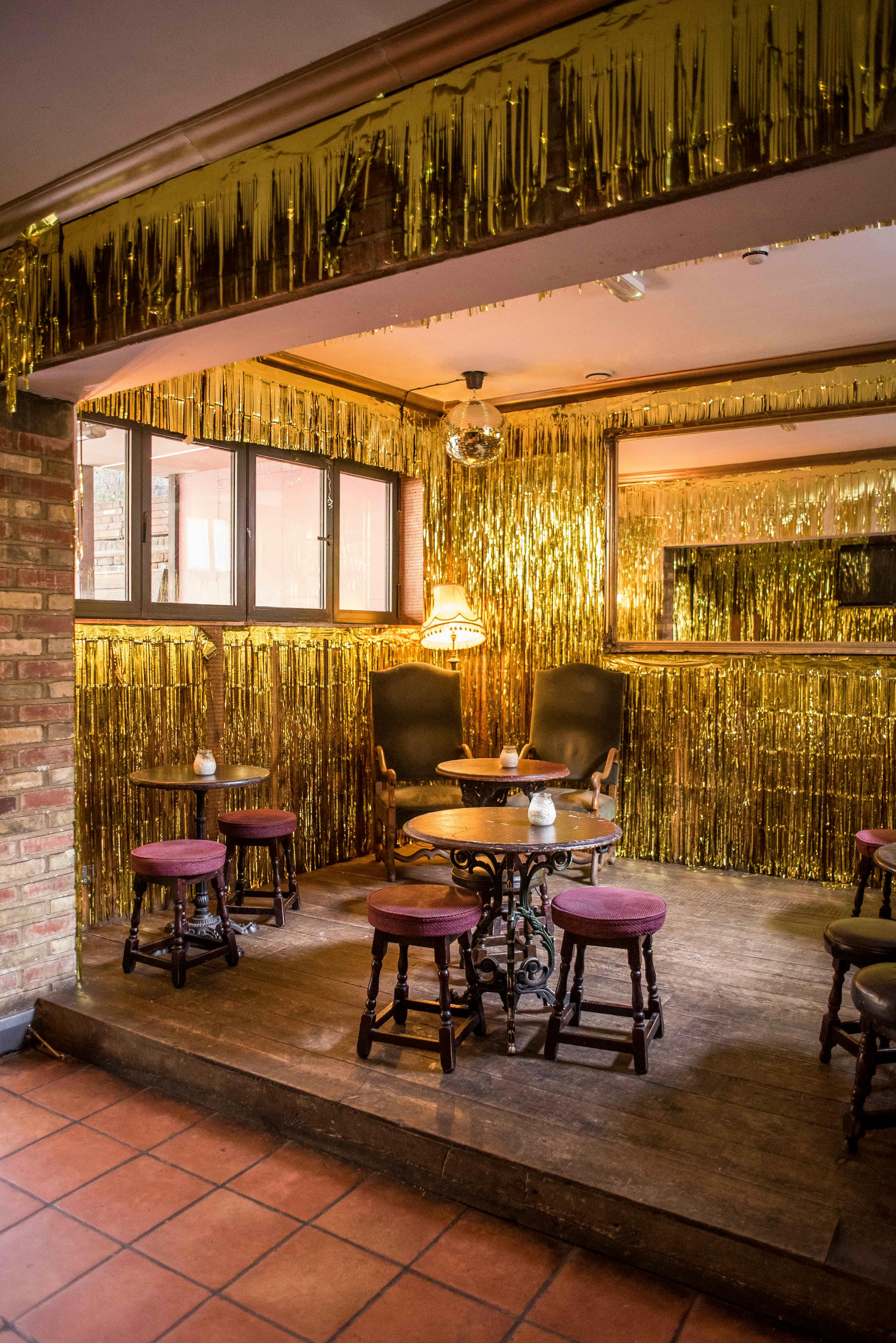 Private room at Abbey Tavern with gold fringe decor, ideal for intimate gatherings and parties.