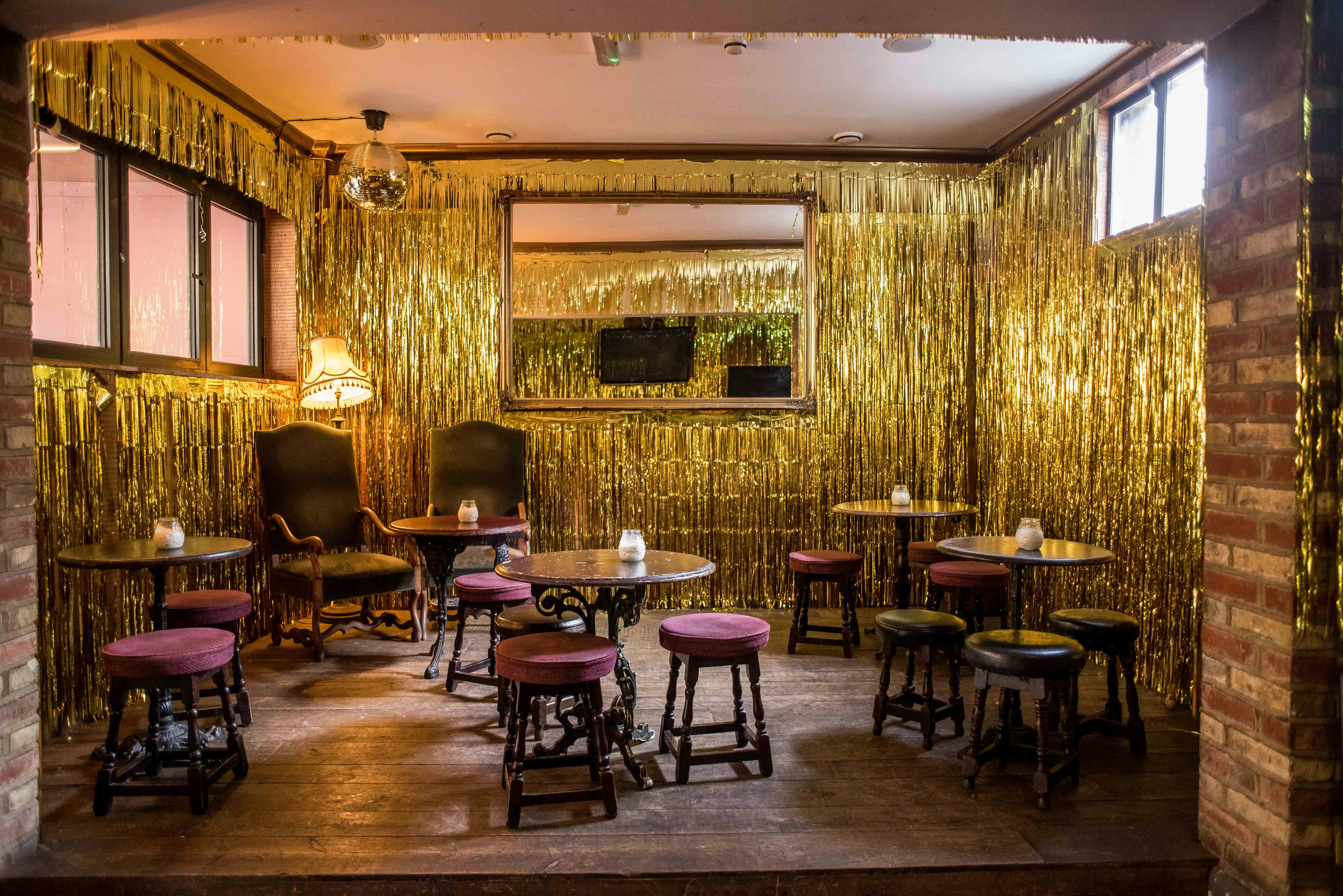 Private room at Abbey Tavern with gold fringe decor, ideal for parties and celebrations.