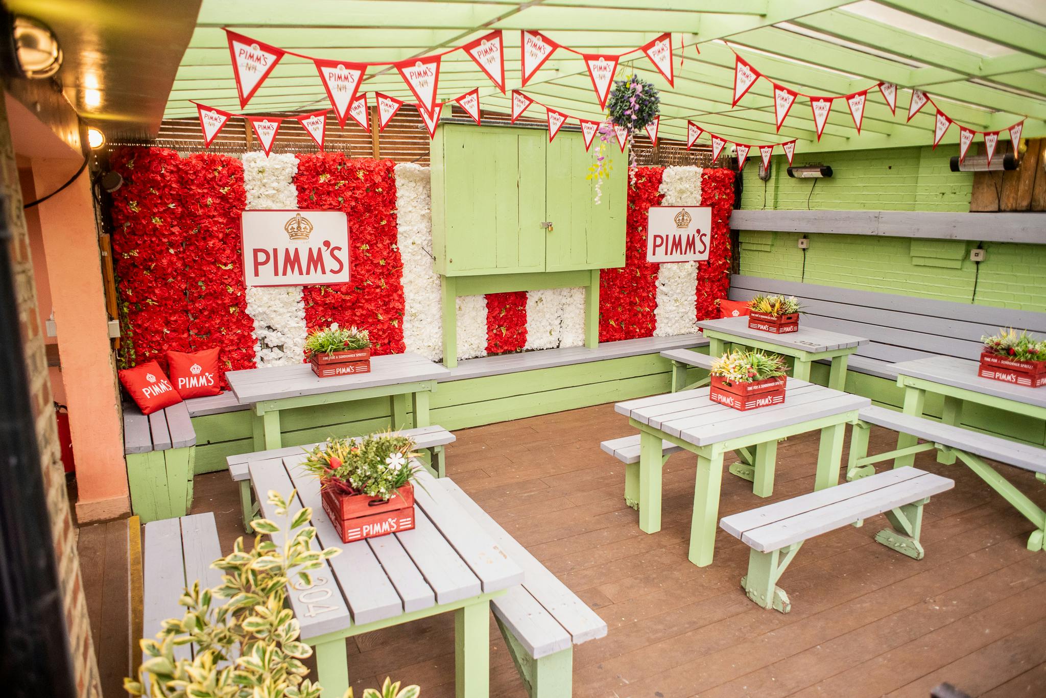 Roof Terrace at Abbey Tavern with red floral backdrop, ideal for summer parties and gatherings.