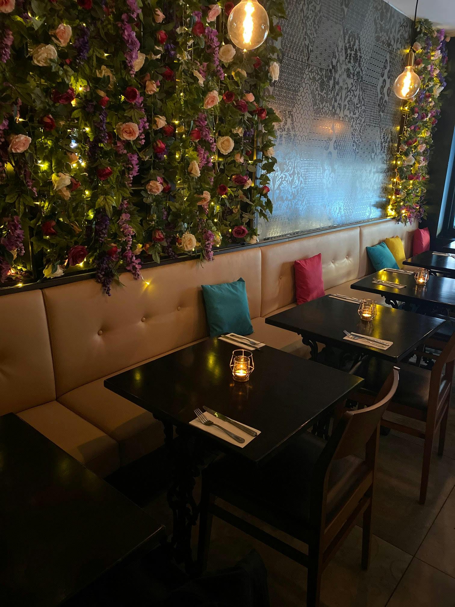 Elegant dining space at Broski Lounge with vibrant floral backdrop for intimate events.