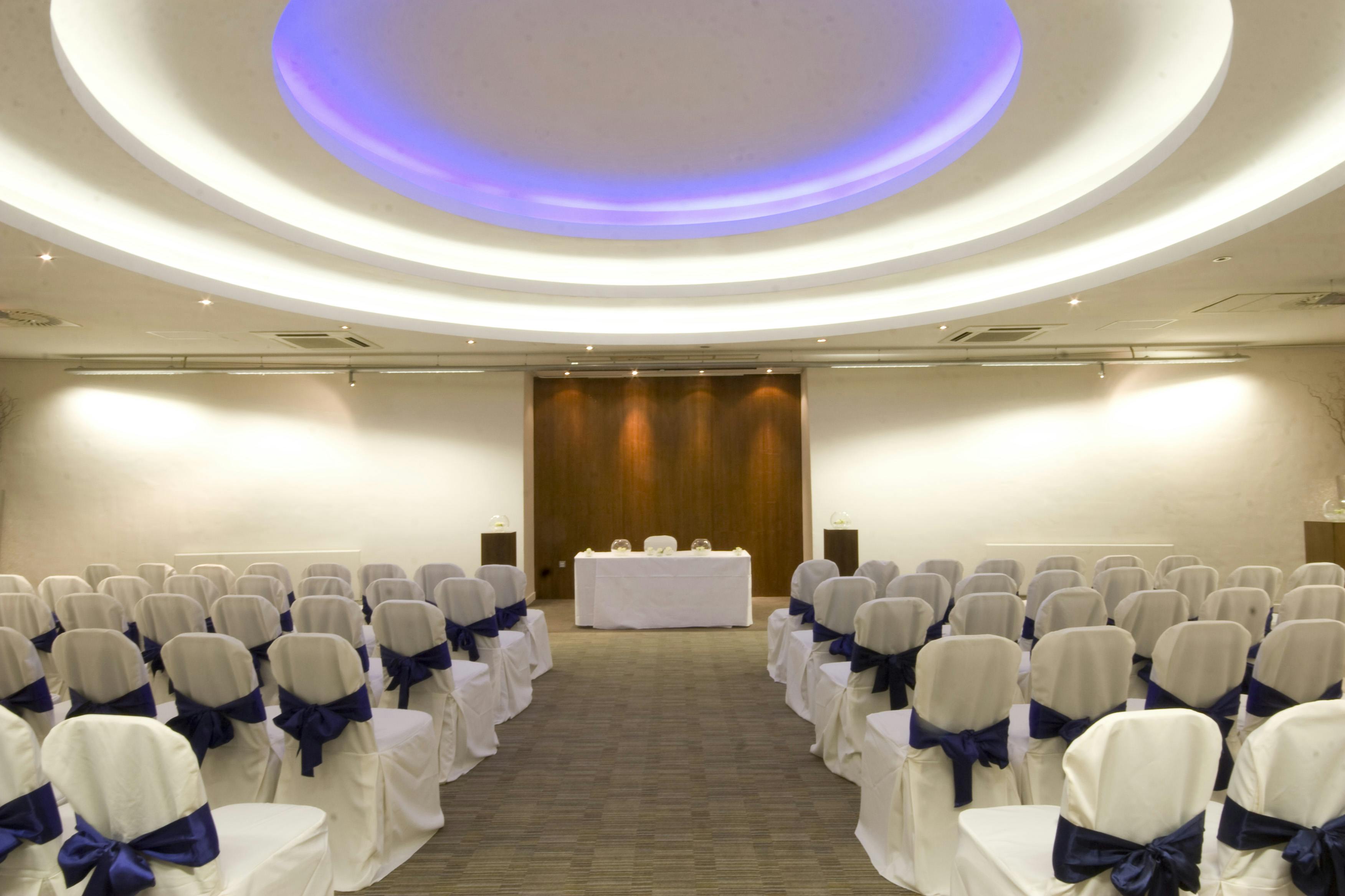 Apex Suite event space with blue-sashed chairs, ideal for conferences and gatherings.