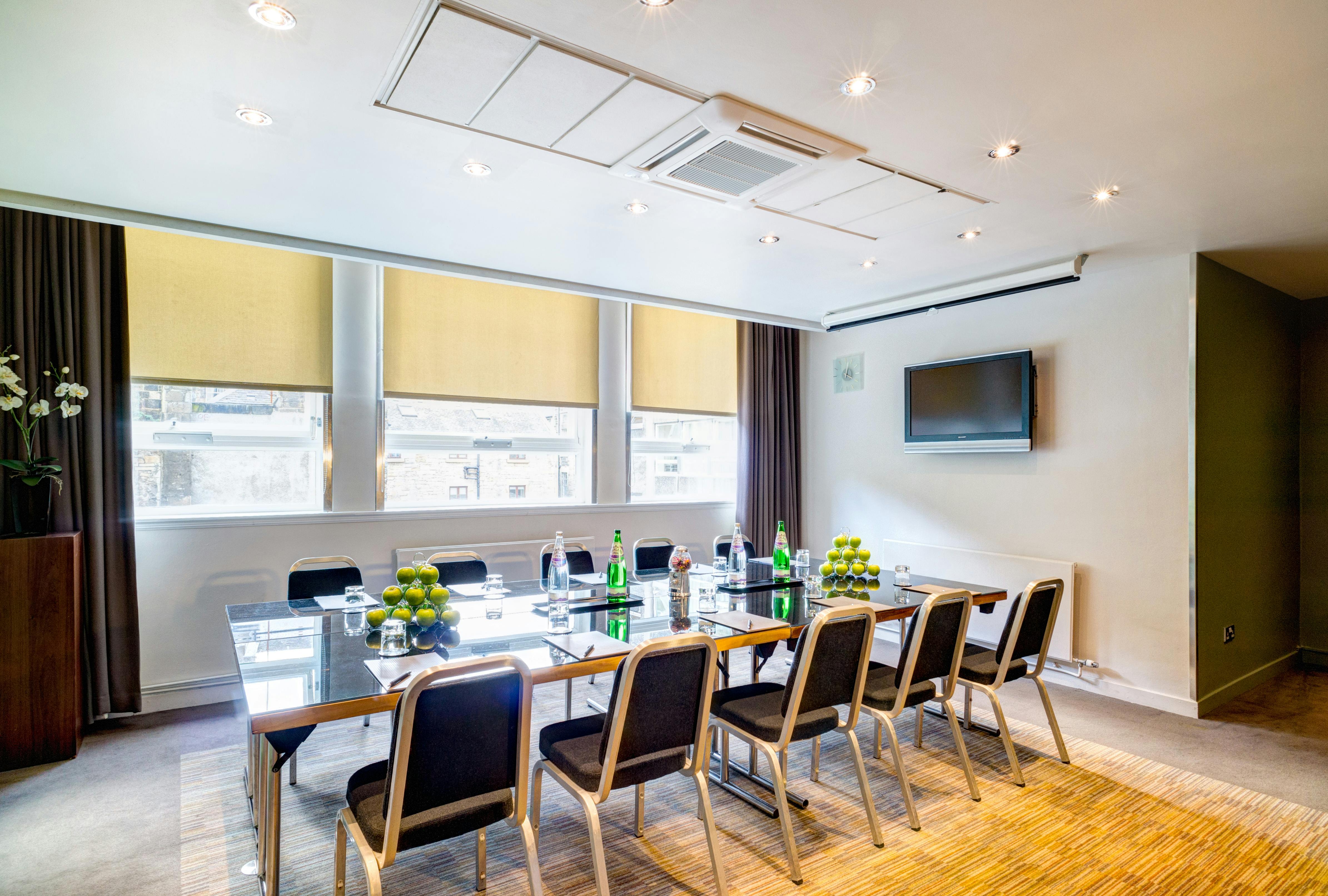 Modern meeting room in Apex Grassmarket Hotel, featuring a sleek glass table for conferences.