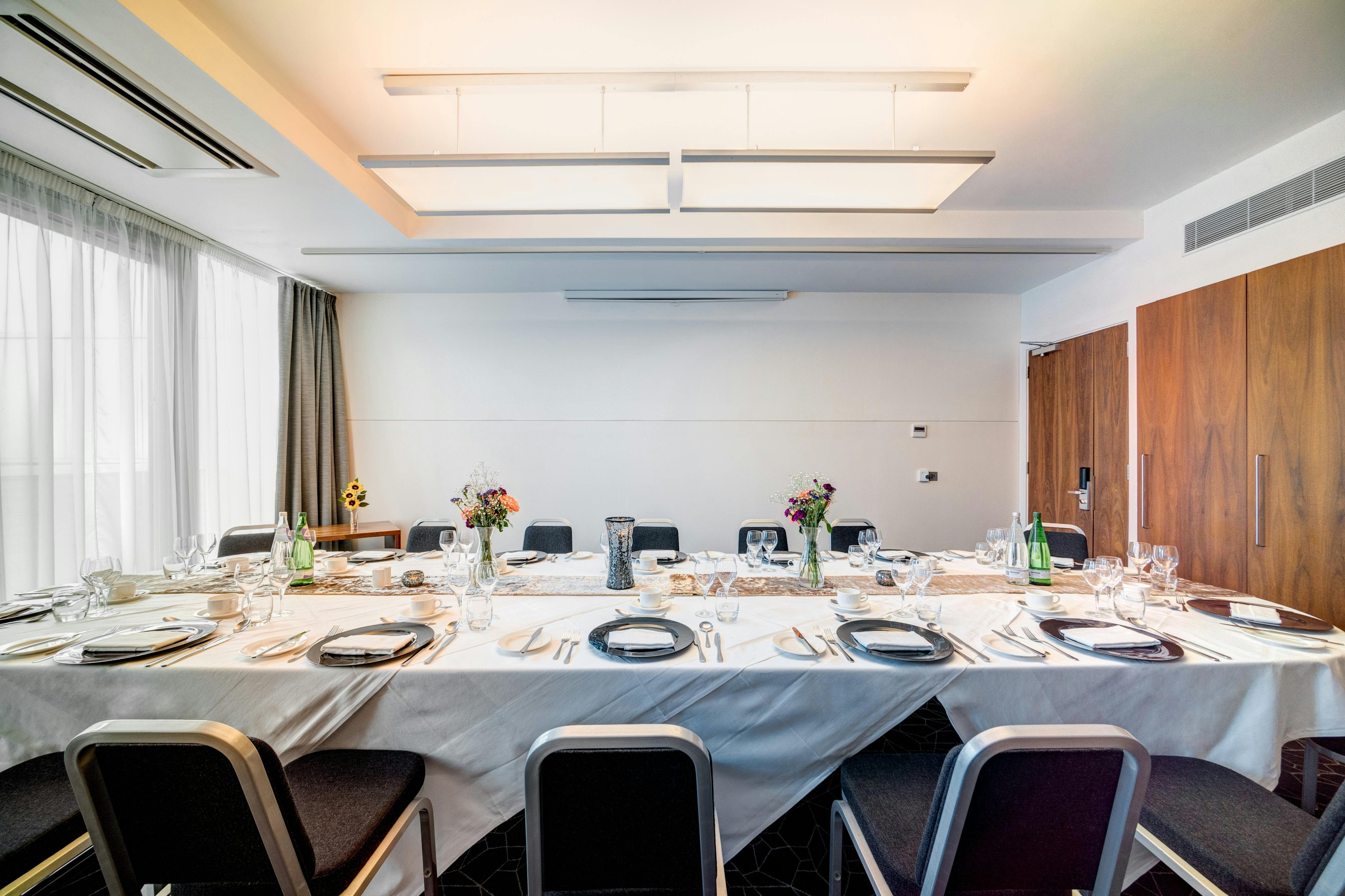 Intimate meeting room with elegant table setting in Apex City Quay Hotel, ideal for events.