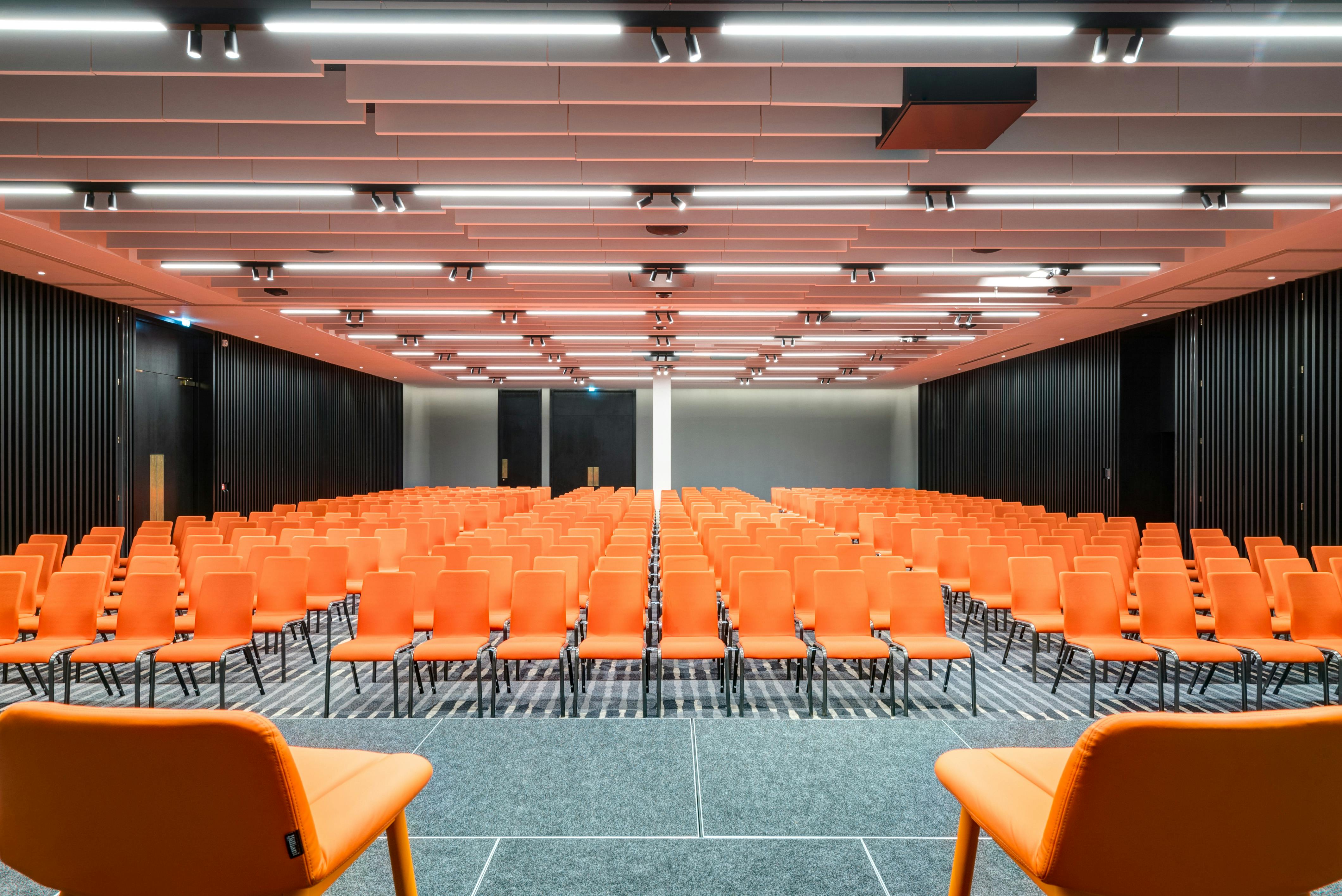 Modern conference space in Apex City of Bath Hotel with vibrant orange chairs.