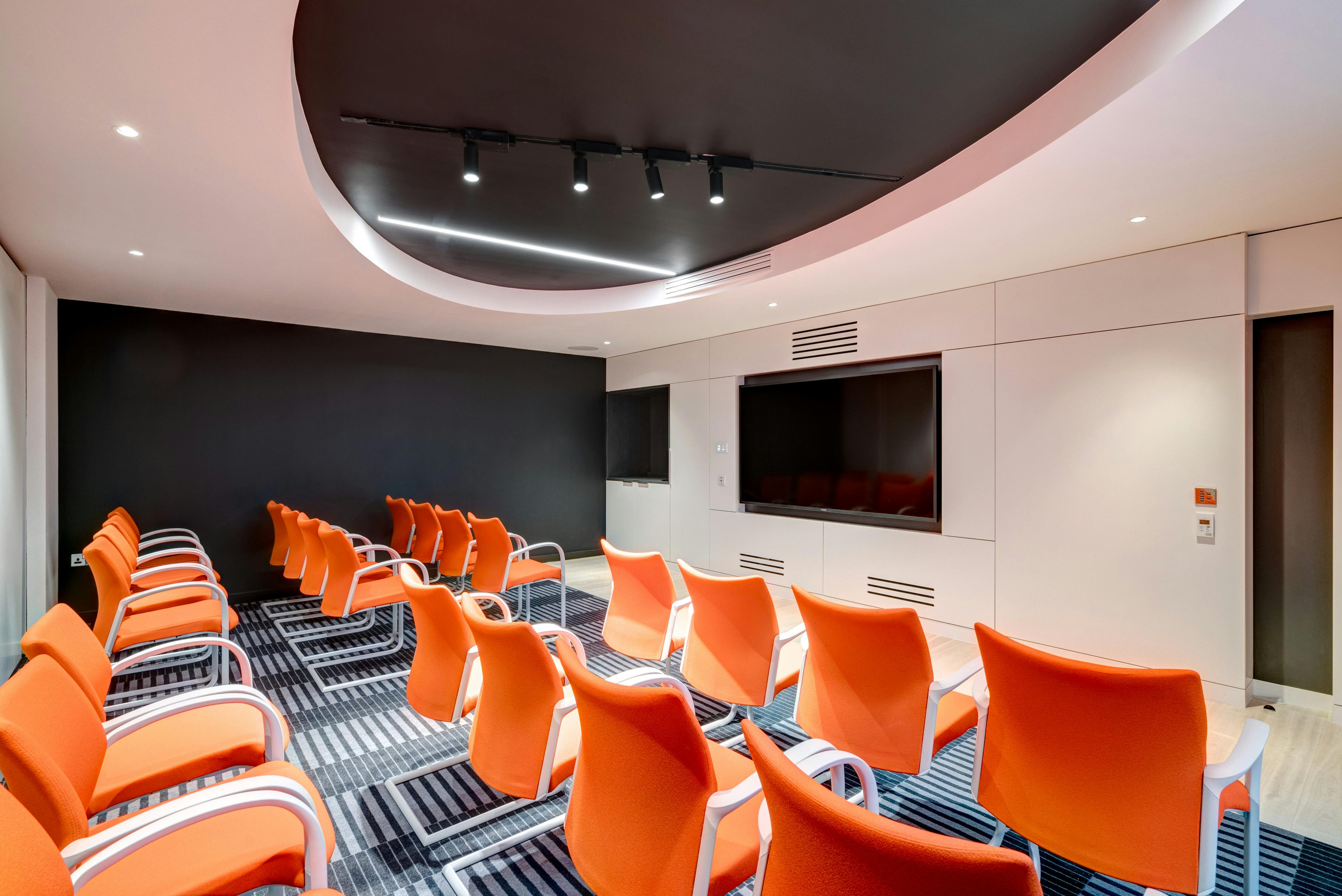 Modern meeting room at Apex City of Bath Hotel with vibrant orange chairs for workshops.